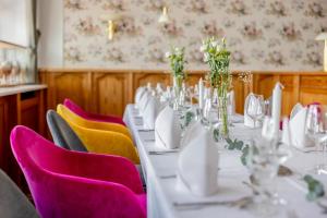 a dining room with a white table and purple chairs at Hotel Friese in Norderney