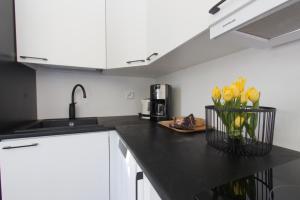 a kitchen counter with a vase of yellow flowers on it at Hotel & Resort Sallavalkea in Salla
