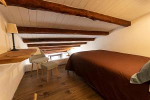a bedroom with a bed and a desk and a chair at La Casetta nel Borgo in Montalbano Elicona