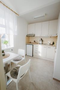 a kitchen with white cabinets and a table and chairs at Penzion Albertovec in Opava