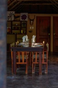 a dining room table with chairs and a table set with napkins at Kelora Bush Camp in Hoedspruit