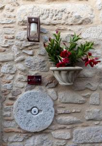 a stone wall with a sink and flowers on it at La Casetta nel Borgo in Montalbano Elicona