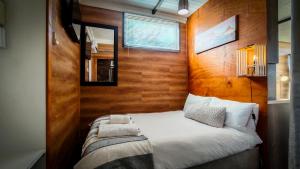 a bedroom with a white bed with a wooden wall at Studios @ Delver in Parys