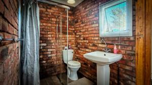 a brick bathroom with a toilet and a sink at Studios @ Delver in Parys +22 photos