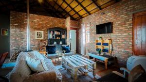 a living room with a brick wall with a couch at Studios @ Delver in Parys