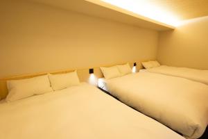 two beds in a room with white pillows at 別府 夕凪 in Beppu