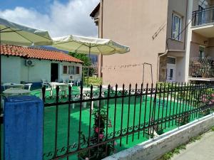 Ein schwarzer Zaun mit einem Sonnenschirm neben einem Pool in der Unterkunft MirkasHouse in Limenas