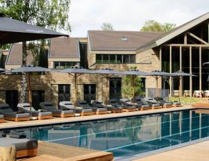a swimming pool with lounge chairs and umbrellas at Alexa Nida Lighthouse Apartment in Nida