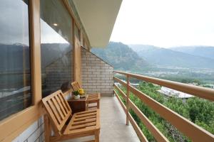 a balcony with two chairs and a view of mountains at Mahadev Villa Manali in Manāli