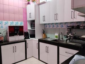 a kitchen with white cabinets and a microwave at Save Sweet Home in Fuvahmulah