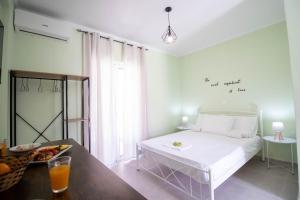 a bedroom with a bed and a table with a bowl of fruit at Ladina Comfort Studios in Lygia