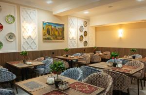 a restaurant with tables and chairs in a room at Hotel KAMILA Prime in Samarkand