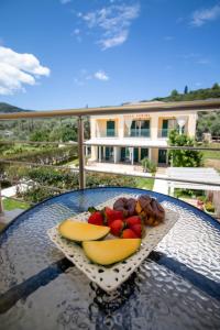 a plate of fruit on a table on a balcony at Ladina Comfort Studios in Lygia