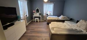 a room with two beds and a flat screen tv at The Yellow House in Boden