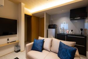 a living room with a white couch with blue pillows at 別府 夕凪 in Beppu