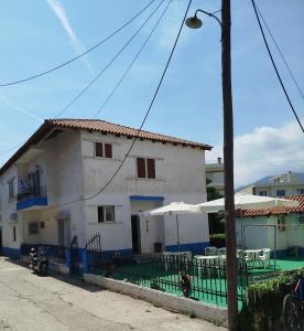 a white house with tables and umbrellas in front of it at Mirkashouse in Limenas