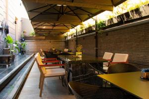 a restaurant with tables and chairs in a room at Vila-L Hotel in Tirana