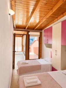 a room with three beds and a ceiling with wood at Terminal Comfort Apartament in Tirana