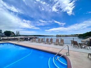a swimming pool with chairs and a view of the water at LOTO fun at 21 Lakeview Condo in Osage Beach