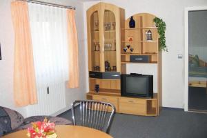 a living room with a tv and a wooden book shelf at Haus Bauer Ferienwohnung 1 in Wasserburg