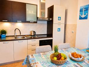 a kitchen with a table with a bowl of fruit on it at Apartment RB in Omišalj