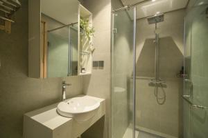 a bathroom with a sink and a glass shower at TS Apartment in Hanoi +43 photos