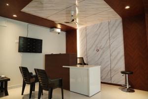 a room with a bar with chairs and a counter at Hotel Vijaya Comfort in Hyderabad