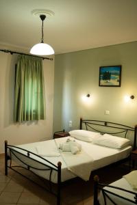 a bedroom with two beds and a light fixture at Angela's studios in Elafonisos