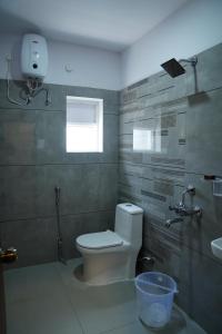 a bathroom with a toilet and a sink at Hotel Vijaya Comfort in Hyderabad
