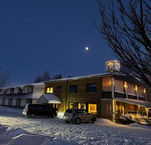 two cars parked in a parking lot in front of a building at Hotel & Resort Sallavalkea in Salla