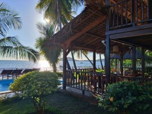 a restaurant on the beach with the ocean in the background at Villa MAYANKI in Dzamandzar