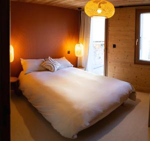a large white bed in a room with a window at Ouréa in Génos +4 photos