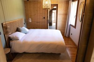 a bedroom with a large white bed in a room at Ouréa in Génos