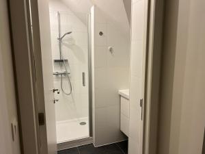 a white bathroom with a shower and a sink at Martinique in Chaumont-Gistoux +4 photos