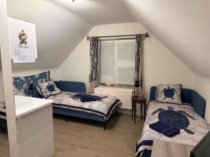 a attic room with two beds and a window at Martinique in Chaumont-Gistoux