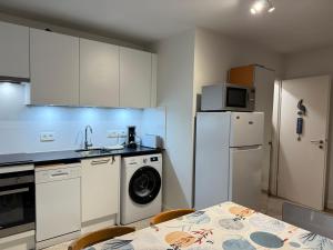 a kitchen with a table and a white refrigerator at Martinique in Chaumont-Gistoux