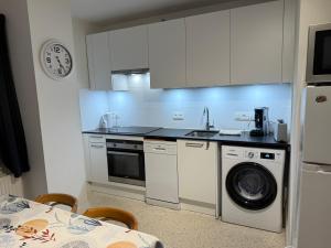 a kitchen with a sink and a washing machine at Martinique in Chaumont-Gistoux