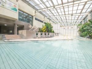 a swimming pool in a building with a glass ceiling at Hotel Kirishima Castle in Kirishima