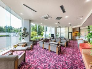 a waiting room with chairs and tables and windows at Hotel Kirishima Castle in Kirishima