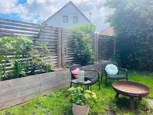 a garden with chairs and tables and a fence at Appartement Morgensonne in Egling