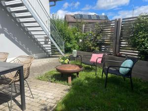a patio with chairs and a table and a bench at Appartement Morgensonne in Egling +25 photos