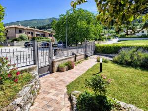 a garden with a fence and a walkway at Appartamento B&B Del Piano in Gualdo Tadino