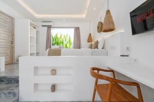 a white living room with a white couch and a chair at Villa Ruta I - Sumptuous 2BR Luxury Villa next to Luna Beach Club and Nyanyi Beach in Tanah Lot