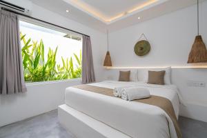 a bedroom with two beds and a large window at Villa Ruta I - Sumptuous 2BR Luxury Villa next to Luna Beach Club and Nyanyi Beach in Tanah Lot