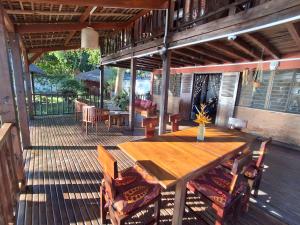 an outdoor deck with a wooden table and chairs at Villa MAYANKI in Dzamandzar