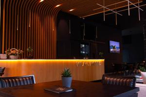 a restaurant with a table and chairs and a bar at Vila-L Hotel in Tirana