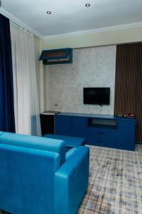 a living room with a blue couch and a tv at Ganja Hotel in Ganja