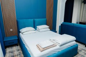 a blue room with a bed with towels on it at Ganja Hotel in Ganja +47 photos