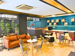 a restaurant with tables and chairs and a couch at Smile Hotel Titiwangsa Pekeliling Sentul in Kuala Lumpur