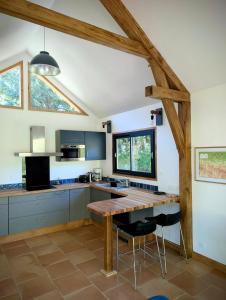 a kitchen with a wooden table and some chairs at Tinyhouse insolite - Au bout du chemin - 10 min de Foix in Baulou
